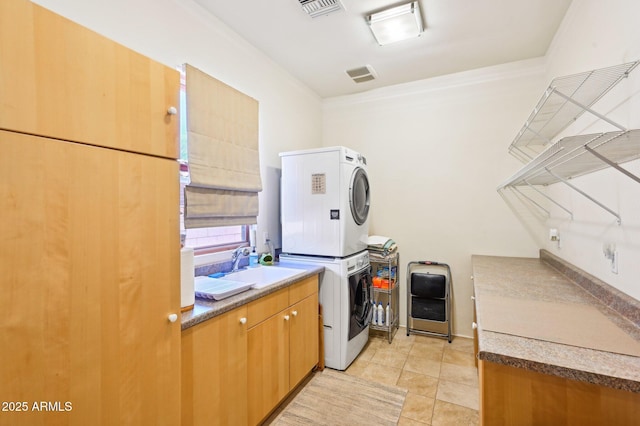 washroom featuring light tile patterned floors, cabinet space, visible vents, stacked washer / dryer, and a sink