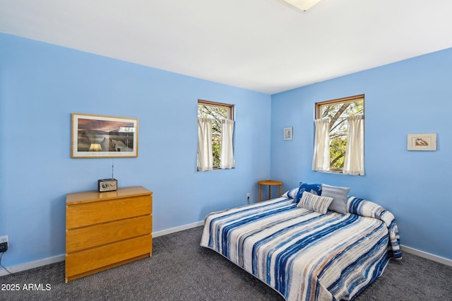 bedroom with baseboards and dark carpet