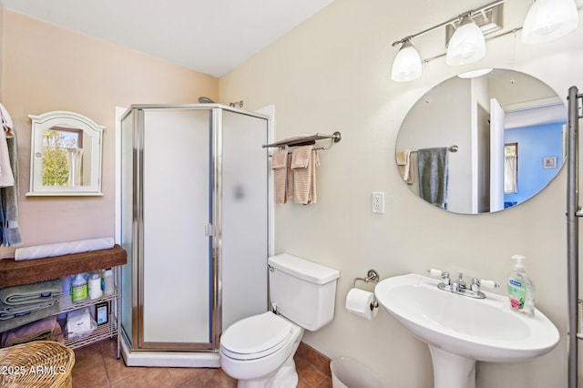 full bathroom featuring toilet, a stall shower, tile patterned flooring, and a sink