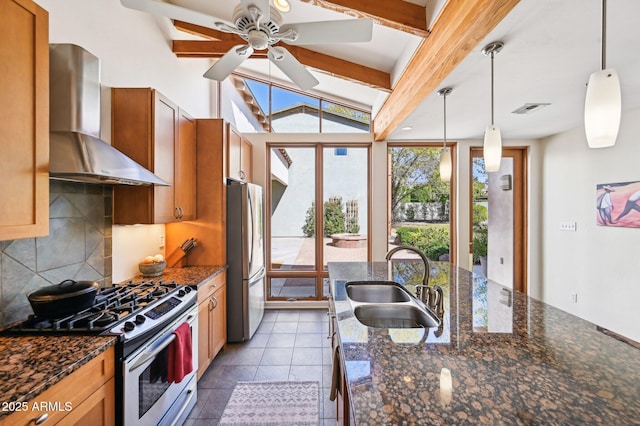 kitchen featuring stainless steel appliances, a sink, visible vents, backsplash, and wall chimney exhaust hood