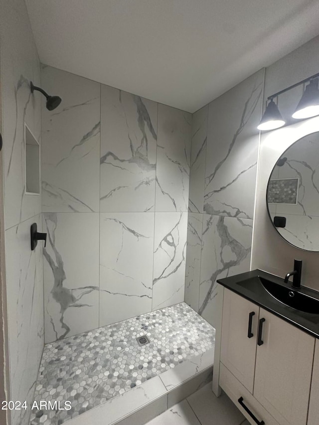 bathroom featuring a tile shower and vanity