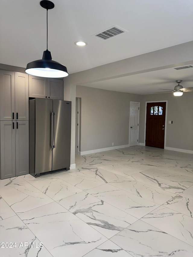 kitchen featuring high quality fridge, gray cabinetry, ceiling fan, and hanging light fixtures