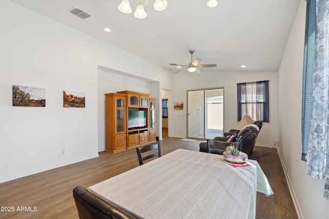 bedroom with baseboards, visible vents, vaulted ceiling, and wood finished floors