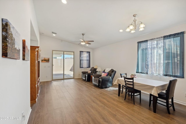 dining area with recessed lighting, ceiling fan with notable chandelier, wood finished floors, baseboards, and vaulted ceiling