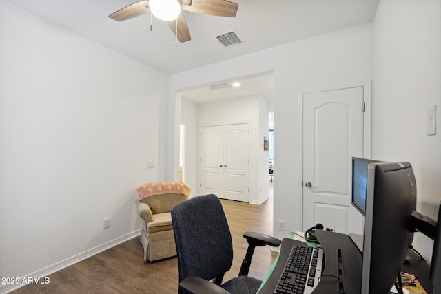 office area with a ceiling fan, visible vents, baseboards, and wood finished floors