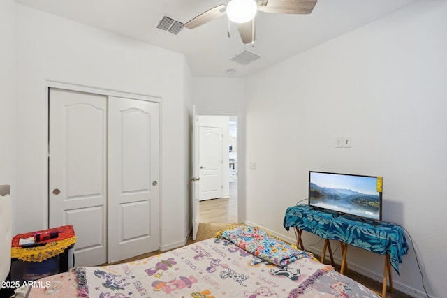 bedroom featuring baseboards, visible vents, ceiling fan, and a closet