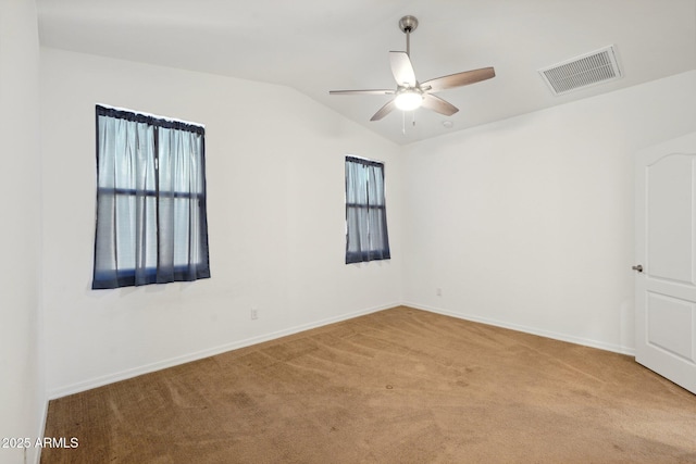 unfurnished room with baseboards, visible vents, ceiling fan, vaulted ceiling, and carpet flooring