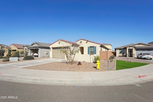 mediterranean / spanish-style home featuring a garage, fence, concrete driveway, a tiled roof, and stucco siding