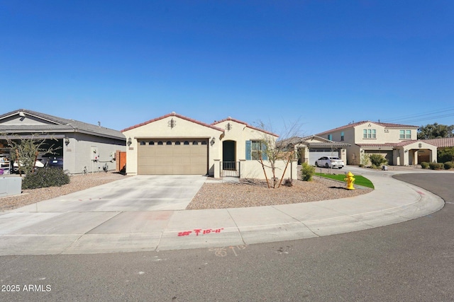 mediterranean / spanish-style home with a garage, driveway, a tiled roof, and stucco siding