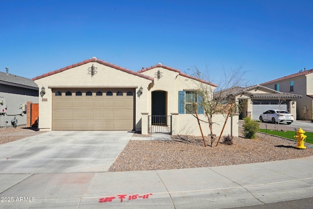 mediterranean / spanish-style house with a garage, concrete driveway, a tiled roof, and stucco siding