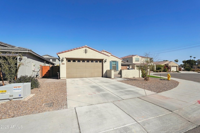 view of front facade featuring a garage, fence, driveway, a tiled roof, and stucco siding