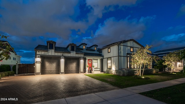 view of front of property with a garage and a lawn