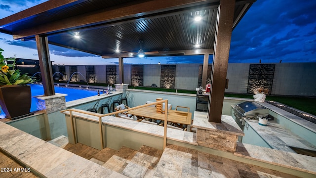 pool at dusk featuring pool water feature