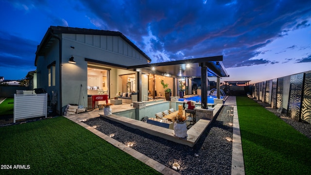 rear view of house featuring a yard, a patio, and a fenced in pool