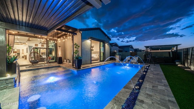 view of swimming pool with pool water feature and a patio area