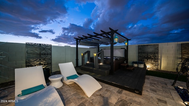 patio terrace at dusk featuring a pergola