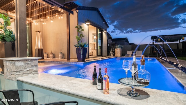 view of swimming pool featuring pool water feature and a patio area