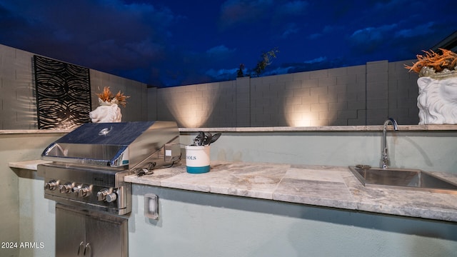 patio terrace at twilight featuring sink and area for grilling