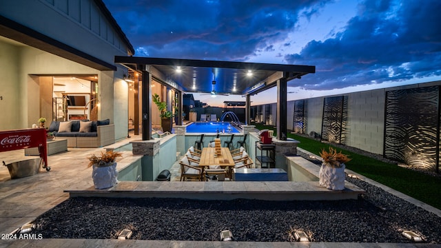 patio terrace at dusk with pool water feature and outdoor lounge area