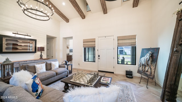 living room with beamed ceiling, a chandelier, and a towering ceiling