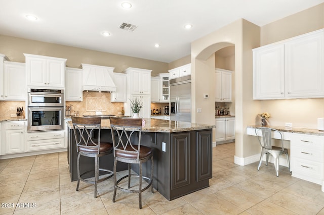 kitchen with a kitchen island, white cabinetry, and appliances with stainless steel finishes