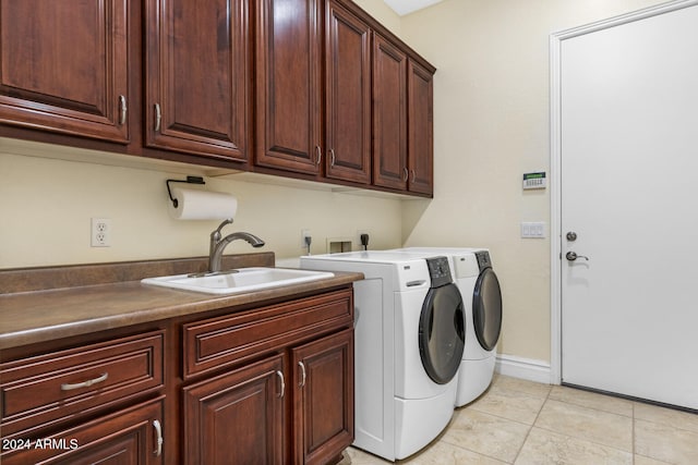 washroom with cabinets, light tile patterned floors, sink, and washing machine and dryer