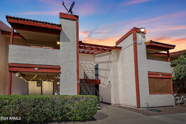 property exterior at dusk with a pergola