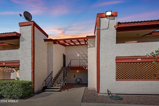 property exterior at dusk with a patio area