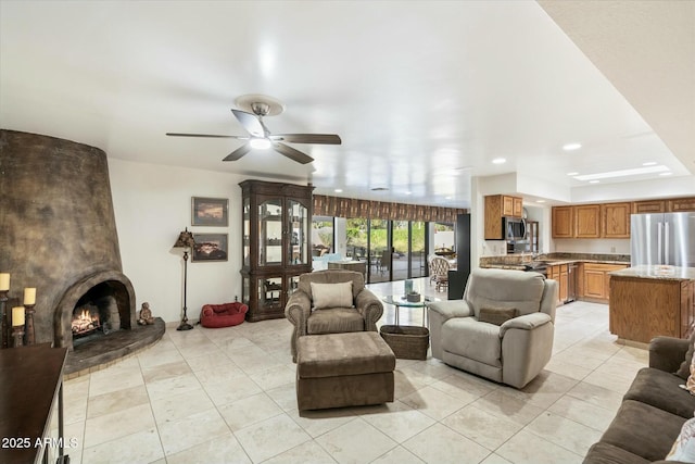 living area with light tile patterned floors, a fireplace, and a ceiling fan