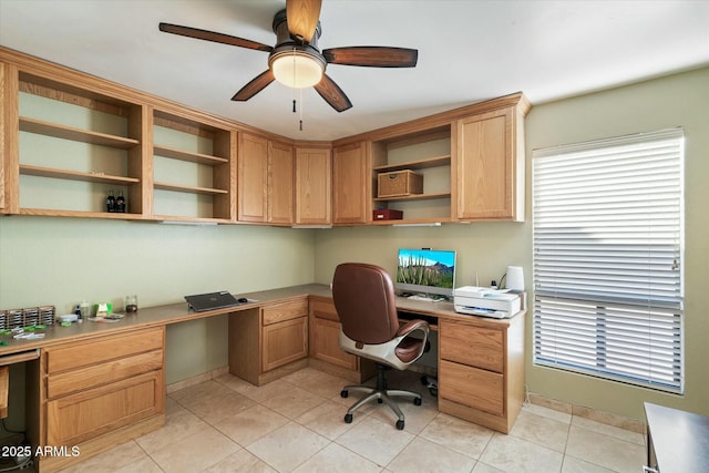 office space with light tile patterned flooring, a ceiling fan, and built in study area