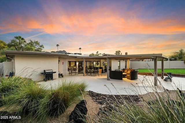 rear view of property featuring fence, a patio, and an outdoor hangout area