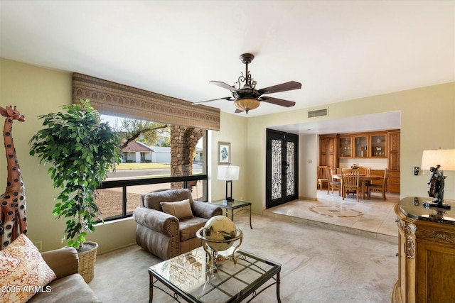 living room with ceiling fan and visible vents