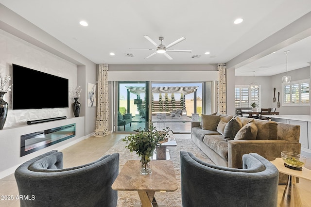 living room with ceiling fan and a wealth of natural light