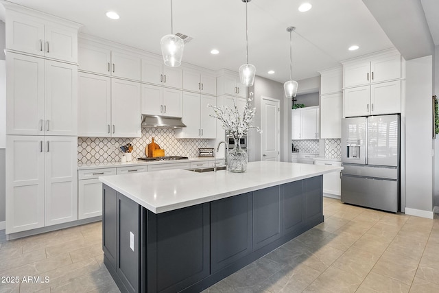 kitchen with decorative light fixtures, white cabinetry, a center island with sink, and refrigerator with ice dispenser