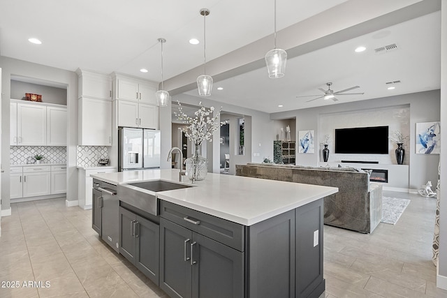 kitchen featuring sink, a center island with sink, white cabinetry, and white refrigerator with ice dispenser