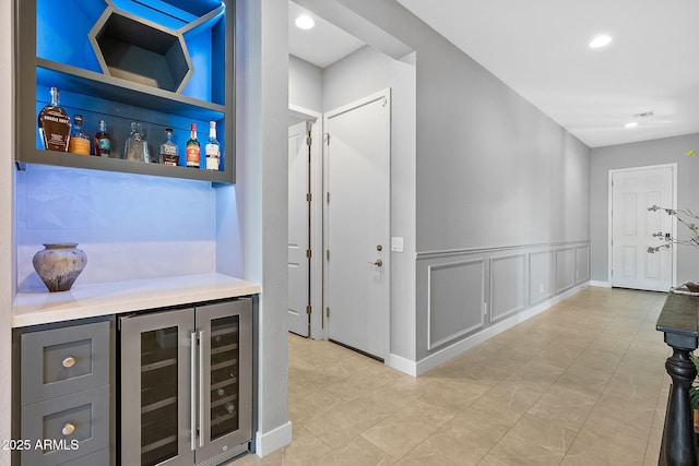 bar with built in features, gray cabinetry, and wine cooler