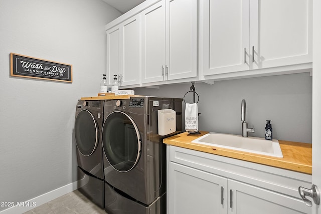 laundry area with sink, light tile patterned flooring, cabinets, and washing machine and clothes dryer