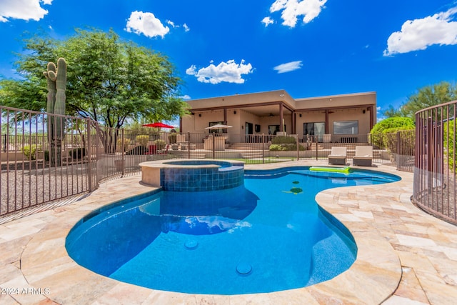 view of swimming pool featuring a patio and an in ground hot tub