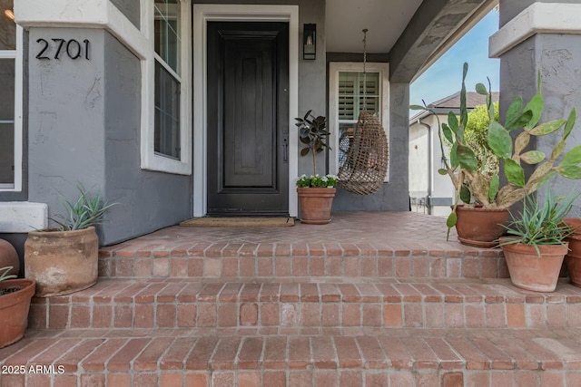 entrance to property featuring stucco siding