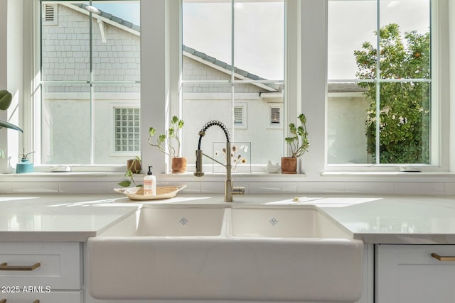 details featuring light countertops, white cabinets, and a sink