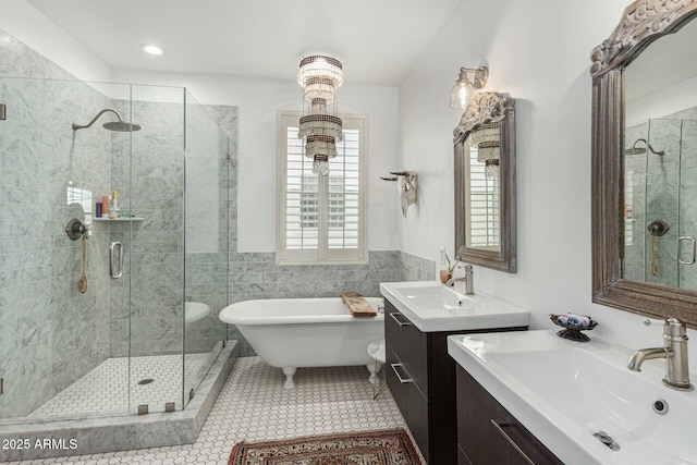 full bathroom featuring tile patterned floors, a sink, a freestanding tub, a shower stall, and two vanities