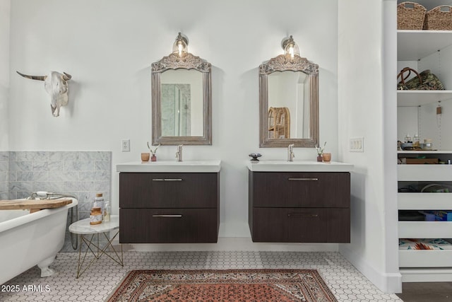 full bath with a sink, two vanities, a freestanding bath, and tile patterned floors