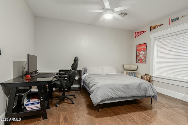 bedroom with a ceiling fan, baseboards, visible vents, and hardwood / wood-style floors