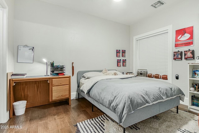 bedroom featuring visible vents and wood finished floors