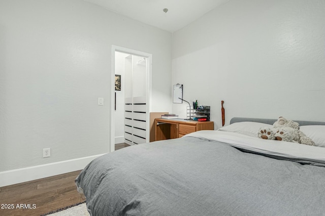 bedroom with baseboards and wood finished floors