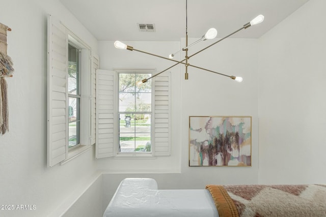 bedroom with multiple windows, visible vents, and a notable chandelier