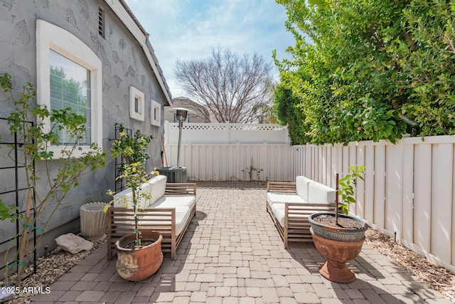 view of patio featuring an outdoor hangout area, cooling unit, and a fenced backyard