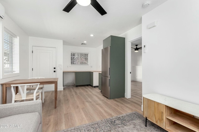 kitchen featuring ceiling fan, recessed lighting, a wall mounted AC, light wood-type flooring, and freestanding refrigerator