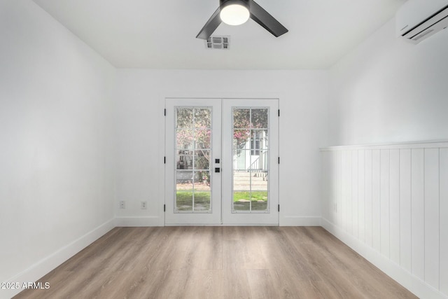 interior space with a wall unit AC, light wood-type flooring, visible vents, and baseboards