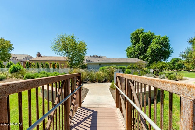 view of home's community with a yard and fence